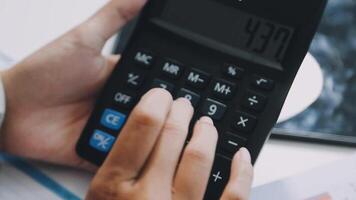 A person is using a calculator to calculate the numbers video