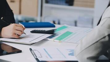 A man and woman are sitting at a desk with papers and a pen video