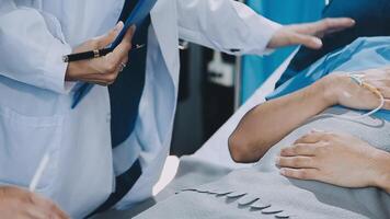 A doctor is holding a patient's hand while another doctor is standing next to him video