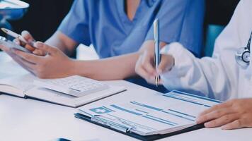 Two doctors are working on paperwork at a desk video
