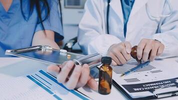 A doctor is writing on a clipboard while another person looks on video