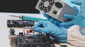 A person in blue gloves is working on a computer video