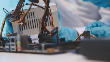 A person in blue gloves is working on a computer video