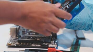 A person in blue gloves is working on a computer video
