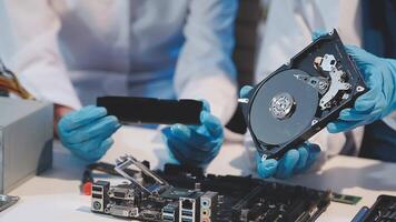Two people working on a computer with a hard drive video