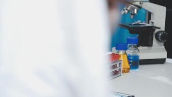 A person in a lab coat looking at a microscope video