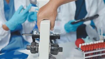 A person in a lab coat is holding a microscope video