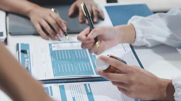A group of people sitting at a table with papers and pens video