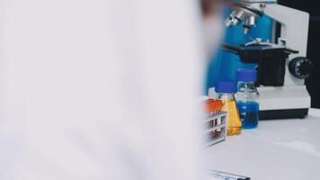 A person in a lab coat looking at a microscope video