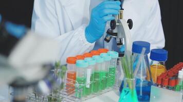 A person in a lab coat is holding a test tube video