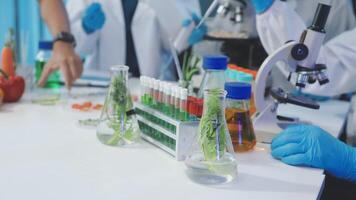 A group of people in lab coats and gloves are working on a project video