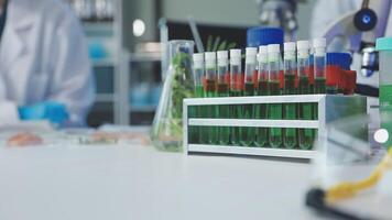 A laboratory with several test tubes and a person in the background video