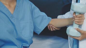 A nurse holding a dumbbell in front of another person video