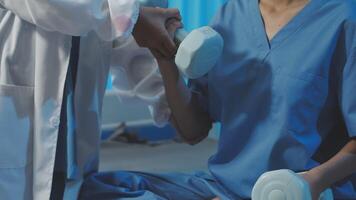 A doctor is helping a patient with a dumbbell video