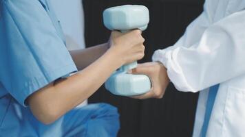 A doctor is holding a dumbbell while another person is holding it video