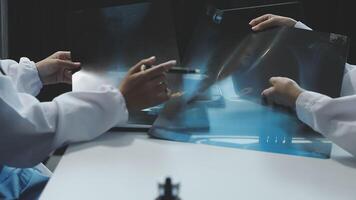 Two doctors examining an x - ray image on a computer video