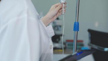 A person in a lab coat holding a tube video