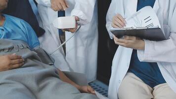 A doctor is holding a clipboard while a patient is lying on a bed video