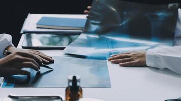 två doktorer är arbetssätt på en dator med en bit av papper video