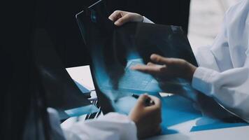 Two people in white lab coats looking at a piece of paper video
