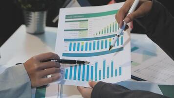 Two people are holding papers with graphs on them video