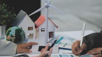 Business people working on a project with a wind turbine video
