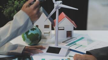 Businessman using laptop to check wind turbine video