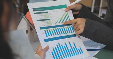 A business person is looking at a chart on a paper video