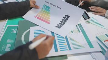 People sitting around a table with papers and graphs video