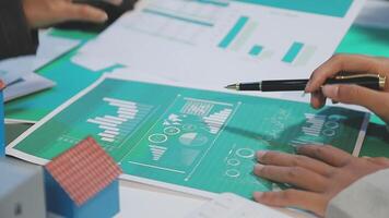 Business people working on a document with graphs and numbers video