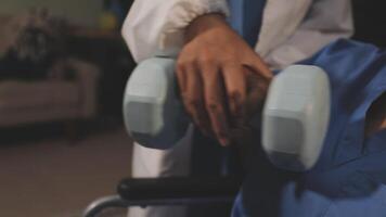 A woman in a wheelchair is holding a dumbbell video