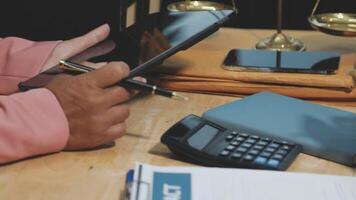 A man is using a tablet to take notes on a legal document video