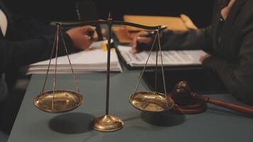 Lawyer and judge sitting at a desk with scales of justice video