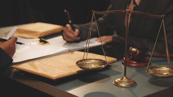 Lawyer and judge sitting at a desk with a scale of justice video