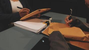 Two people sitting at a table with a pen and paper video