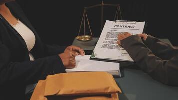 Two people sitting at a table with a contract video