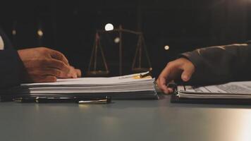 Two people sitting at a table with papers and a scale video