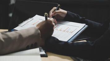 Two people are working on a document with a pen and paper video