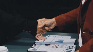 Two business people shaking hands over a desk video