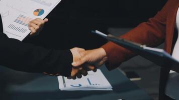 Two business people shaking hands over a table video