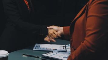 Two business people shaking hands at a table video