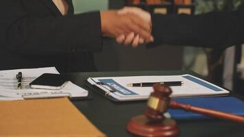 Two lawyers shaking hands over a desk video