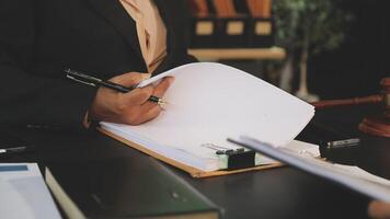 A woman in a suit is writing on a piece of paper video