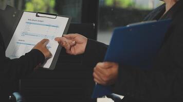 Two business people holding a clipboard and looking at a document video