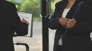 Two business people standing near a bus stop video