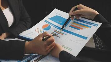 Business people working on a document with graphs and charts video