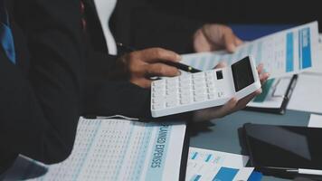 Business people working on paperwork and using a calculator video