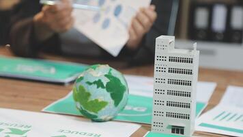 Businessman working on a paper with a globe and a paper with a graph video