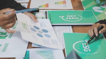 People working on papers with green and net zero logos video
