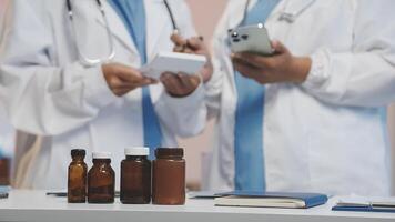 Two doctors are looking at a tablet and bottles video